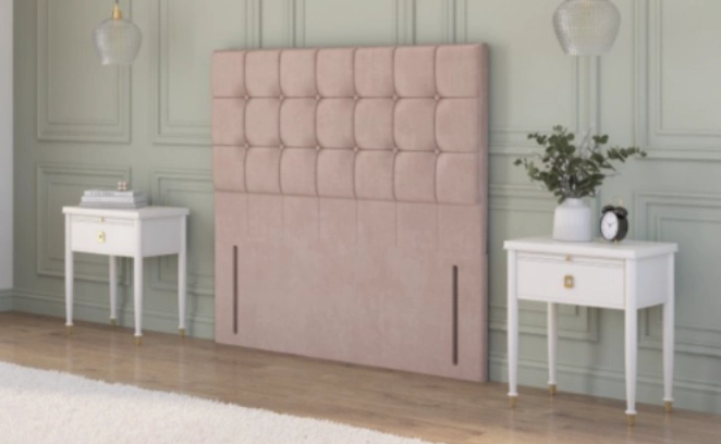  Beige plush velvet strutted headboard with a chesterfield design in a rustic cottage bedroom between two bedside tables.